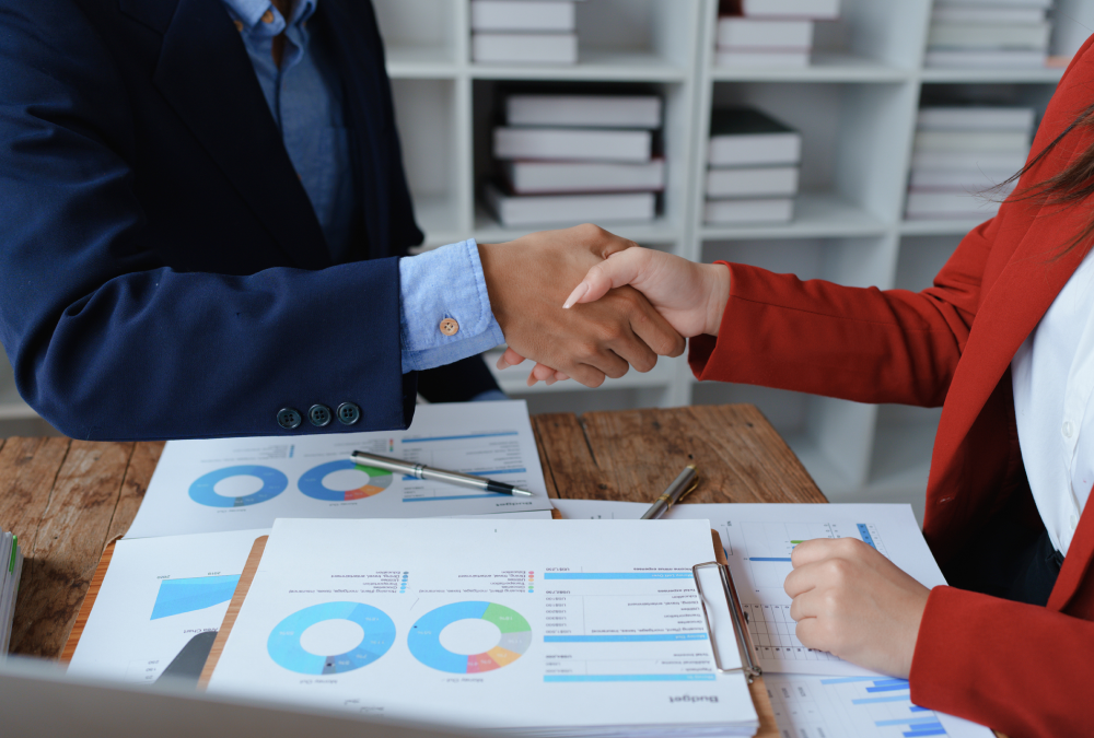 Business handshake over financial documents