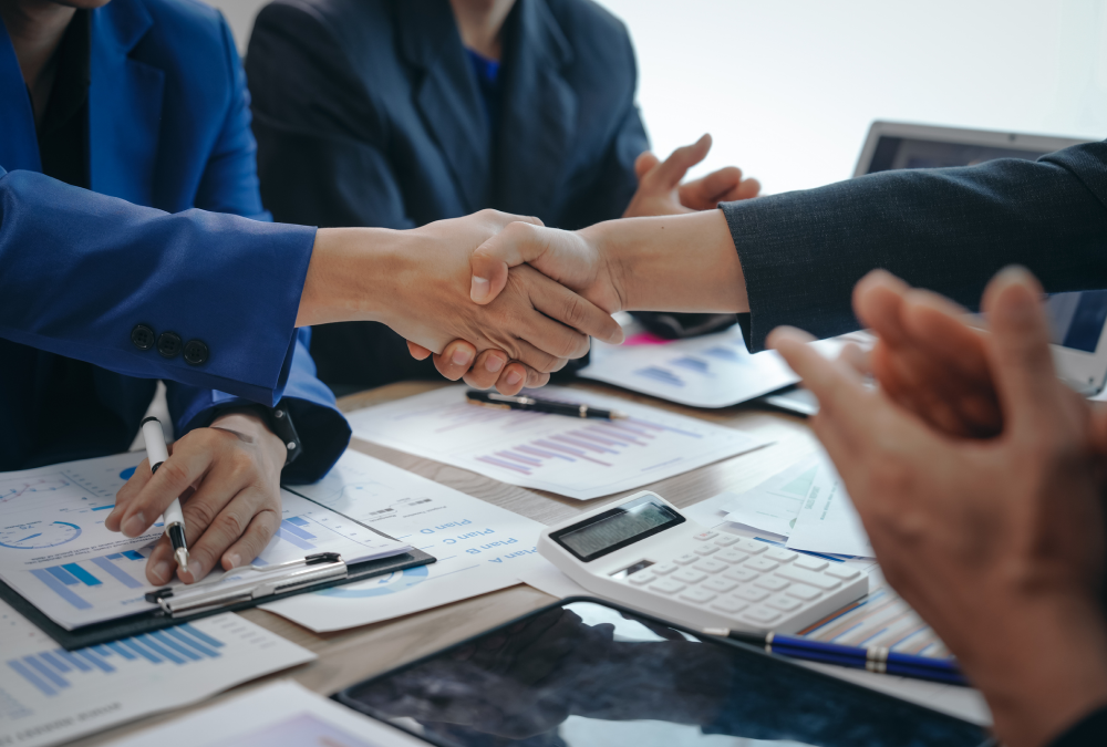Professionals shaking hands at conference table
